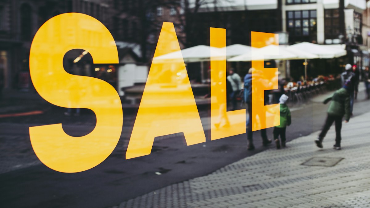 Placa amarela de promoção em vitrine de loja